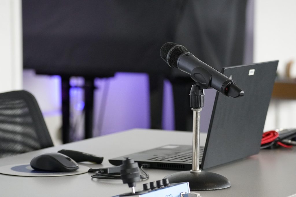 Laptop, conference table, mouse — Top 4 Benefits Of Adopting The Youtube Intro Maker Or Online Video Maker